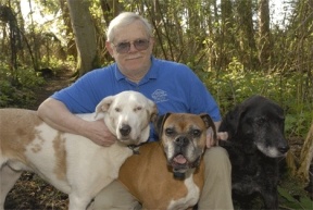 Ron Kerrigan surrounds himself with three of his many canine companions