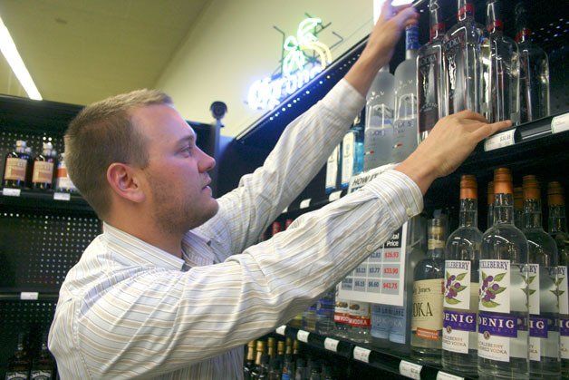 Scot Huntington stocks and checks the supply of liquor at the Goose Community Grocer. The store manager was a bit frazzled June 1 after some complications led to a delayed shipment of liquor.