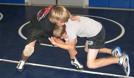South Whidbey wrestlers Ben Jacobson-Ross and Evan Thompson practice their takedown techniques under the critical eye of Falcon coach Jim Thompson.