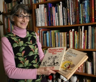 Freeland resident Maria Kelly holds two of the more than 250 cartoon and comic strip books she’s collected.