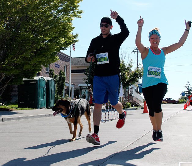 Oak Harbor residents Dan and Kate Junod cross the finish line at the Pawz by the Sea 5K Run/Walk in Langley on Monday. Attendance was estimated at nearly 200.
