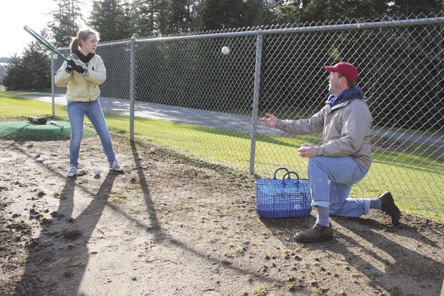 Josie Dodd practices her batting skills with her father