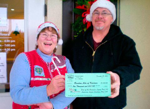 Libby McCauley and Andy Campbell hold a check which represents the $1