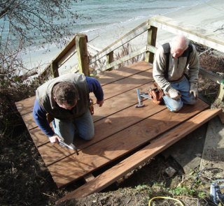 Dave Johnson and Glenn Jones repair the stairs to the beach at South Whidbey State Park last weekend. “It was silly not to have them open