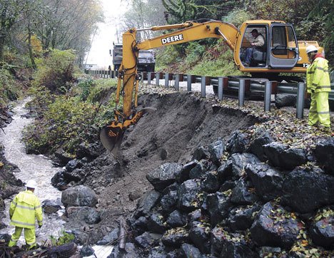 An Island County crew works to repair a rockery along the edge of Glendale Road after high flows in the creek led to slope failures along the roadway earlier this week.