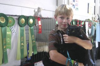 Alex Neal holds Frank after the cat’s return to the county fair.