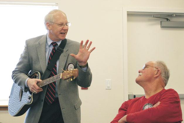 South Whidbey School District Superintendent Fred McCarthy tells a joke to Bob Truelich during a holiday singalong at the Kiwanis meeting on Thursday. McCarthy told his fellow Kiwanians about his retirement after morning meetings where he shared the news with school district employees.