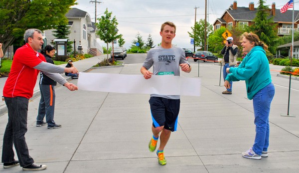 Will Simms crosses the finish line in first place Monday at Pawz by the Sea 5K Run/Walk in Langley.