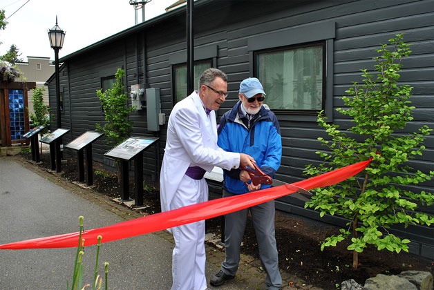 Langley Mayor Tim Callison cuts the ribbon to officially open the Langley History Walk for viewing.