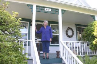 Susanne Paulson stands on the front porch of the Maine Stay
