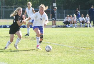 Falcon Julia Iverson watches as freshman McKenzie Peterson battles a Tiger for the ball on Saturday.