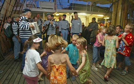 The Shifty Sailors of Whidbey perform in France aboard the Russian Tall Ship 'Mir' much to the joy of several dancing children.
