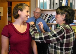 Nancy Barker gives Katie Hicks a flu shot as Dr. Roger Case looks on.