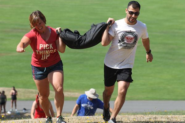 Wendi Hilborn and Chris Andrew carry a sandbag up a hill Community Park. The duo were among 11 teams that competed in the Whidbey Throwdown on Aug. 13.