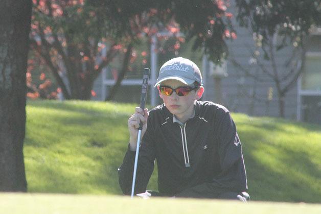 South Whidbey junior boys golfer Ian Saunsaucie plans a putt during Monday’s home match against Cedarcrest.