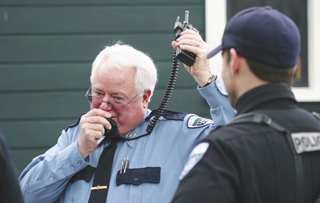Retiring Langley Police Chief Bob Herzberg radios in his final dispatch call outside city hall on Monday. He spent 32 years on the force.