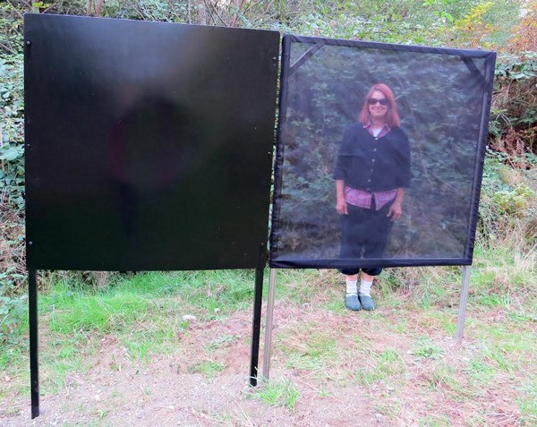 Claudia Pettis stands behind the minimalist “Veils of Reality” installation at Earth Sanctuary.