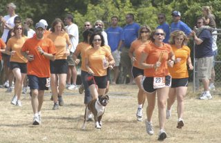 Rebecca Valdivia carries the baton across the finish line for the Island Insanity team Saturday at Langley Middle School. The 11 member co-ed team ran the 187-mile Ragnar Relay from Blaine during a two-day period
