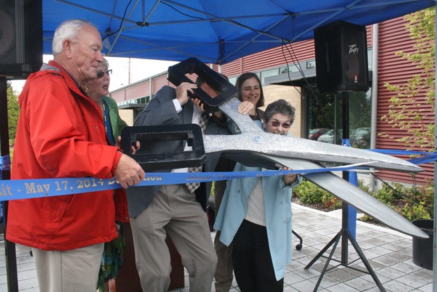 Island Transit Executive Director Martha Rose uses a large pair of scissors to cut the ribbon and officially open the new facility May 17.
