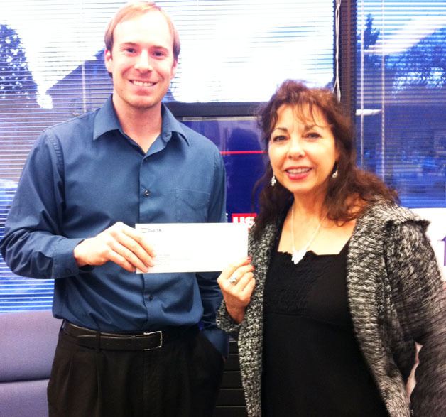 Brandon Turner of US Bank presents Marilynn Norby of the Readiness to Learn Foundation with a check to support the nonprofit ’s work.