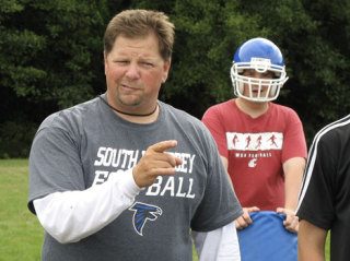 Coach Mark Hodson grimaces in mock anger when a defensive lineman misses his mark on a hand-off during the Falcon's first day of practice Wednesday.