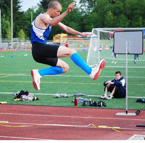 Falcon Will Hallberg flies through the air Friday during his successful shot at a state title in the triple jump.