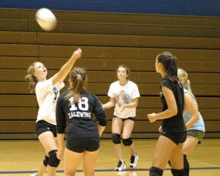Falcon varsity volleyball player Katie Holt back hits the ball as teammates Reilly O’Sullivan