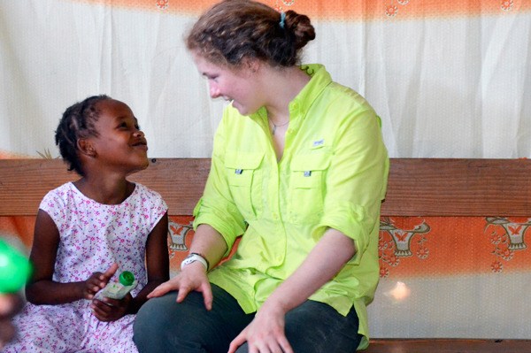 Emma Lungren speaks with a little girl during a recent mission trip to Haiti.
