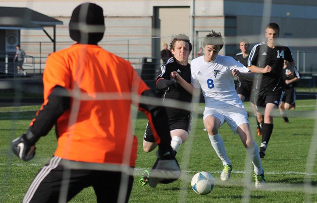 Falcon junior forward Kai da Rosa fights Coupeville senior Brett Arnold for position near the Coupeville goal early in the match on April 18. South Whidbey missed the ensuing penalty kick.