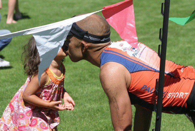 Pedro DeGuzman kisses his daughter after crossing the finish line of the Whidbey Triathlon at South Whidbey Community Park. DeGuzman