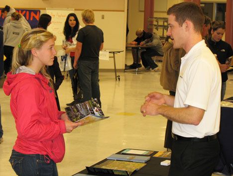 Julia Iversen listens closely to a pitch from a Pacific Lutheran University guidance counselor at a job fair last week at South Whidbey High School.