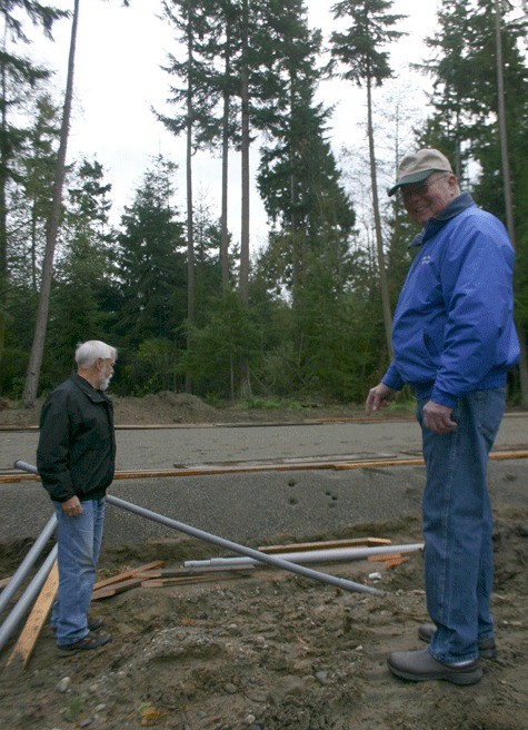 Pete Berg and Richard Johnson point out the water system installed by Johnson and Maurice Aasland at the site of the new Nordic Lodge on Jacobs Road in Coupeville.
