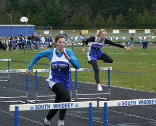 Falcons Cayla Calderwood and Tamara Leonard hurdle their way over the final obstacles during the 100-meter event Thursday at the track and field dual meet with Cedarcrest.