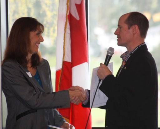 Former Rotary Club president George Henny congratulates first-grade teacher Deborah Davies.