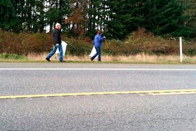 Debra Valis and Steve Shapiro collect trash on Highway 525 on behalf of Rotary Club of Whidbey Westside on Saturday