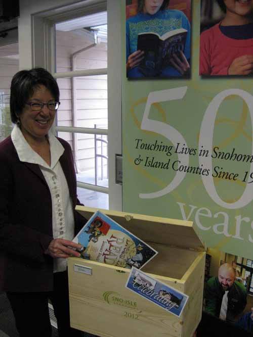 Langley Library staff member Robin Obata stands with the time capsule being prepared for the library’s 50th anniversary with Sno-Isle Libraries. Additional time capsule items are needed and can be dropped off at the library.