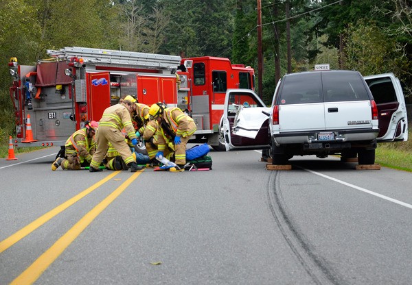 South Whidbey Fire/EMS firefighters help Freeland resident Floyd Fuller following a two-car crash on Fish Road.