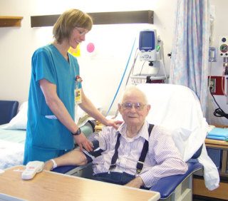 Nurse Annette Fly uses David Graham’s dedicated monitor to check his vital signs.
