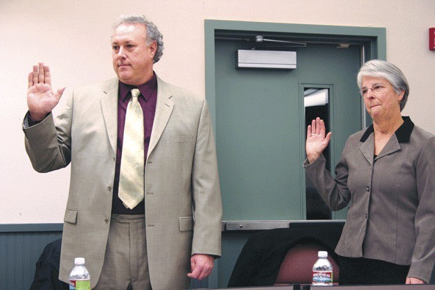 Damian Greene and Linda Racicot take their oaths to faithfully serve the school district at the board meeting Nov. 30. Both won unchallenged seats on the South Whidbey School Board.