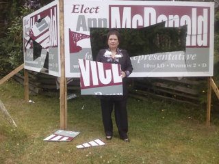 Ann McDonald stands next to one of her destroyed campaign sings in Greenbank.