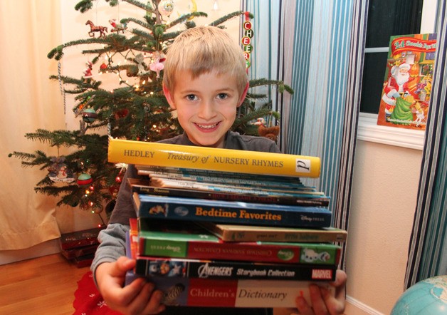 Weston Dill holds up a stack of books
