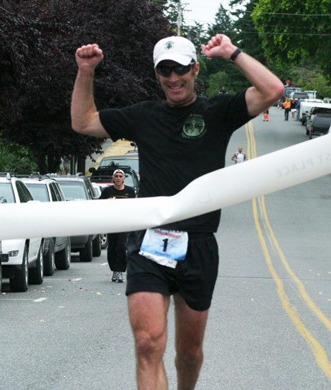 Langley’s Frank Jacques crosses the finish line Sunday in first place after completing the half-marathon in 1 hour