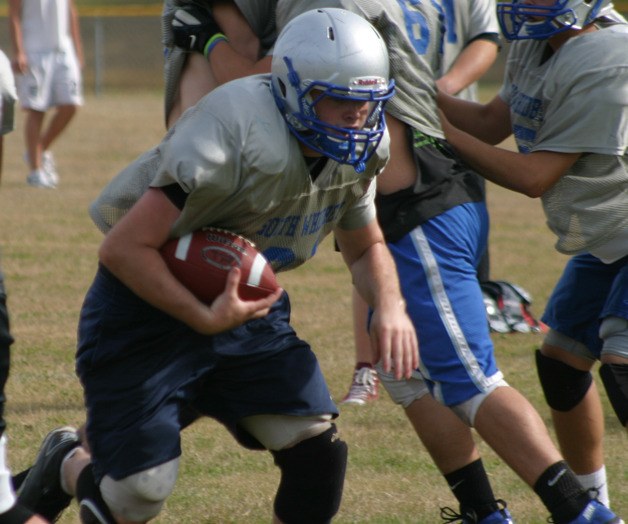Falcon senior running back Pat Monell hits the opening during a recent practice. South Whidbey’s football team hopes its drills and practices will pay off Friday against the Chelan Goats