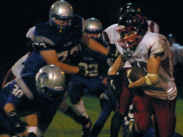 Wolf junior fullback Brett Arnold runs around Falcon senior linebacker Aaron Curfman. Coupeville won The Bucket in the island rivalry game with South Whidbey.