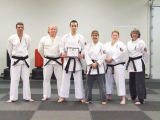 New first-degree black belt Nick Metcalf holds his certificate