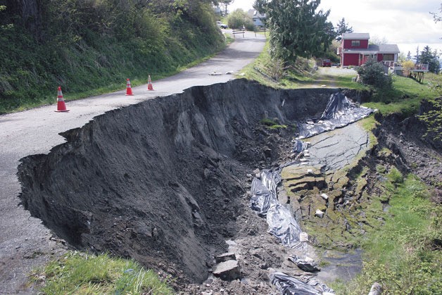 This gaping hole was left behind by a landslide at Bush Point that damaged Susana Drive and carried away part of the driveway of one residence.