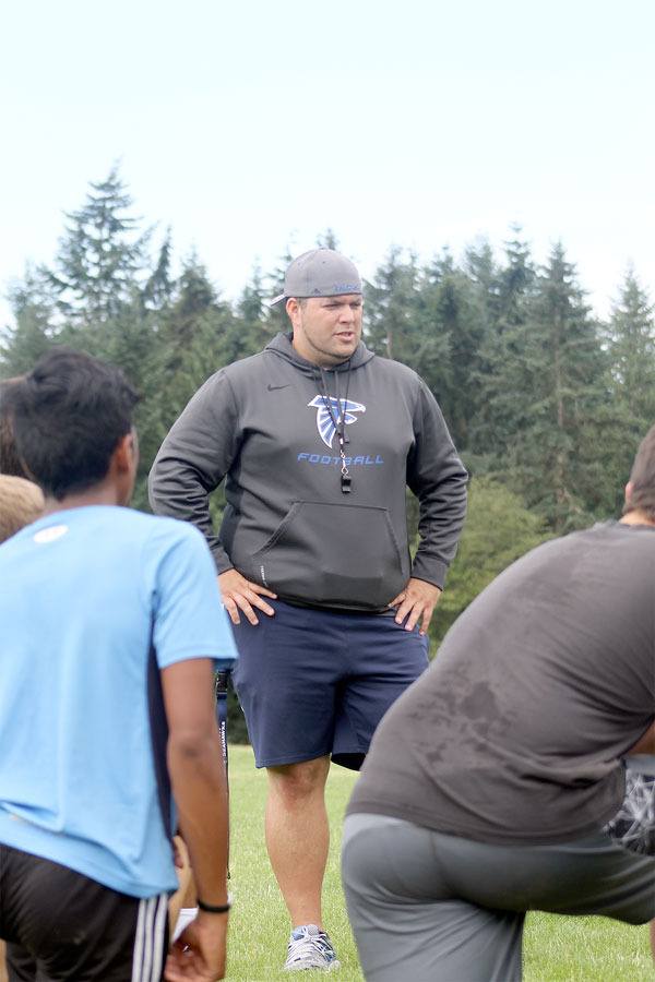South Whidbey football head coach Michael Coe speaks with players after a morning workout in July. Coe is the third coach to run the program in the last three years. Football practices begin on Aug. 19.