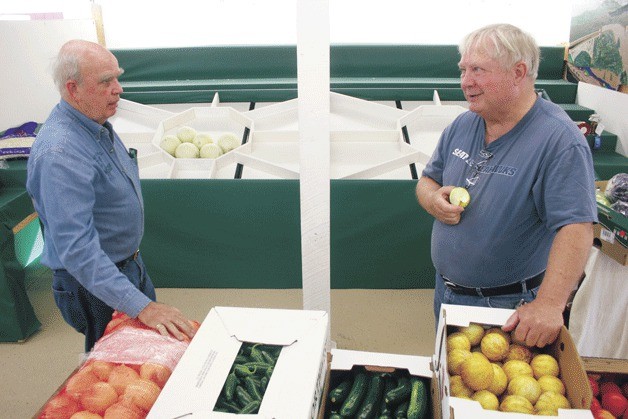 Gary Kay talks with Chuck Prochaska of the Deer Lagoon Grange before the pair begin assembling the grange’s agricultural display at this year’s Island County Fair. The fair opens at 9:30 a.m. Thursday.