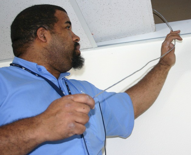 Whidbey Telecom employee Marius Artis wires the security system for the new gun store going in at Ken’s Korner Mall. With cameras and motion detectors to deal with