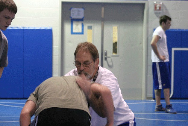 Falcon head wrestling coach Jim Thompson demonstrates a hook maneuver on Tyler Russell during a recent practice.